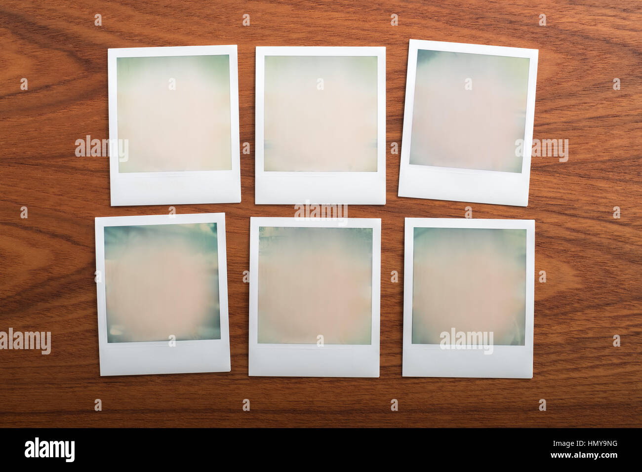 Blank instant print photographs on wooden table. Six Objects. Stock Photo