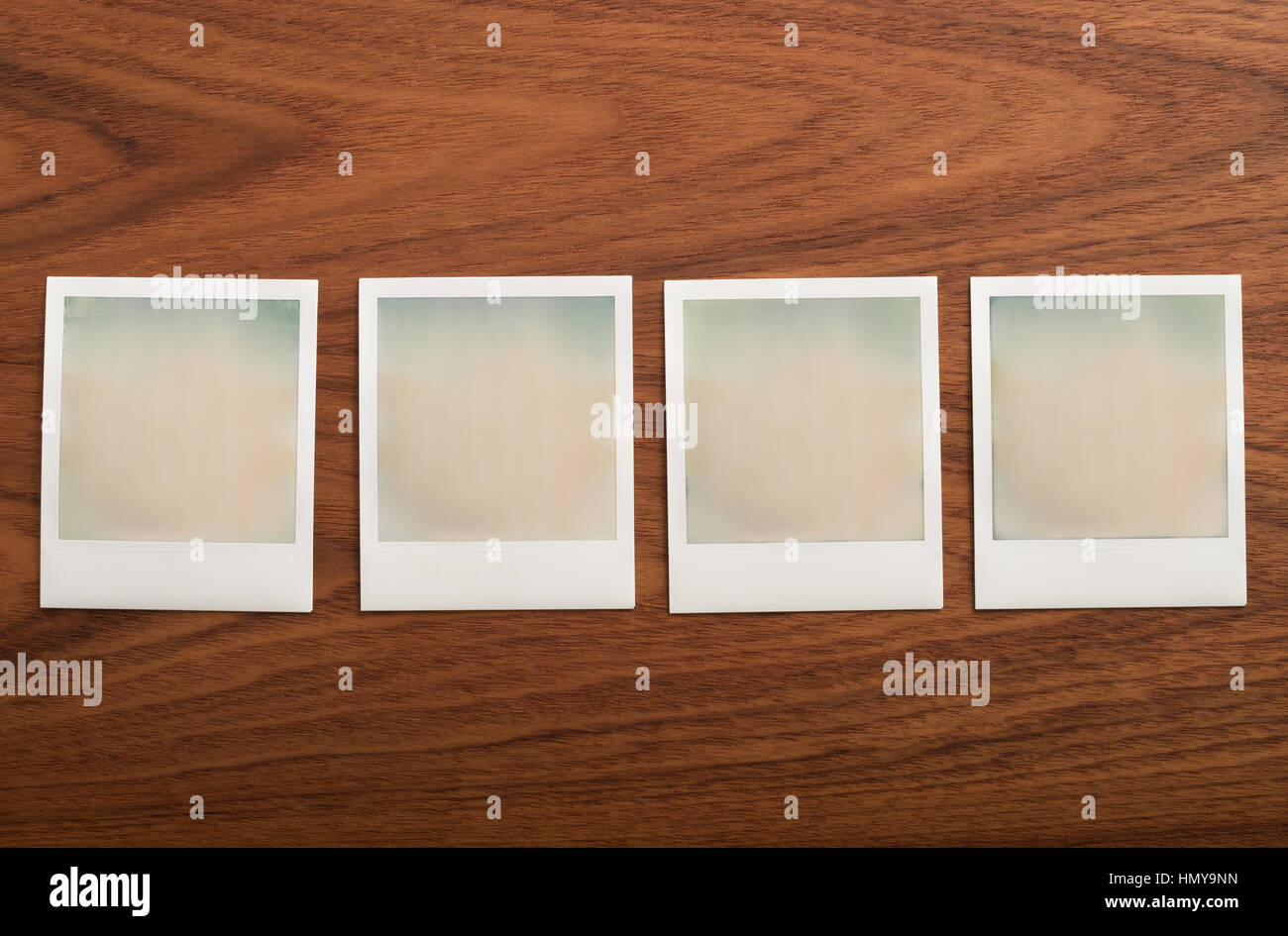 Blank instant print photographs on wooden table. Six Objects in a row. Stock Photo