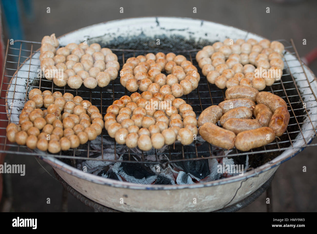 Sausage and streetfood at the walkingstreet nightmarket in the old town of the city of Lampang in North Thailand. Stock Photo