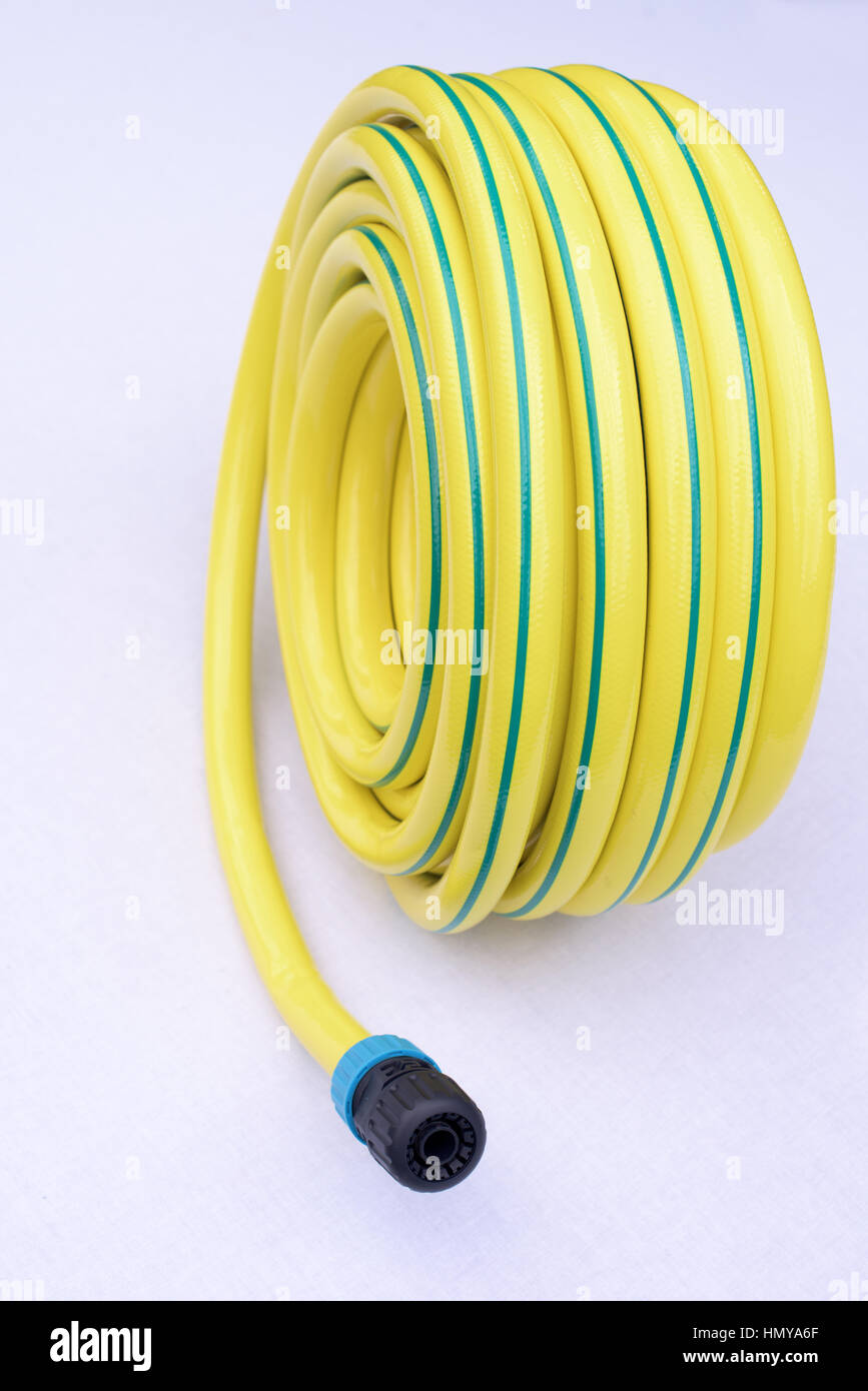 Yellow garden hose-pipe on a  white background Stock Photo