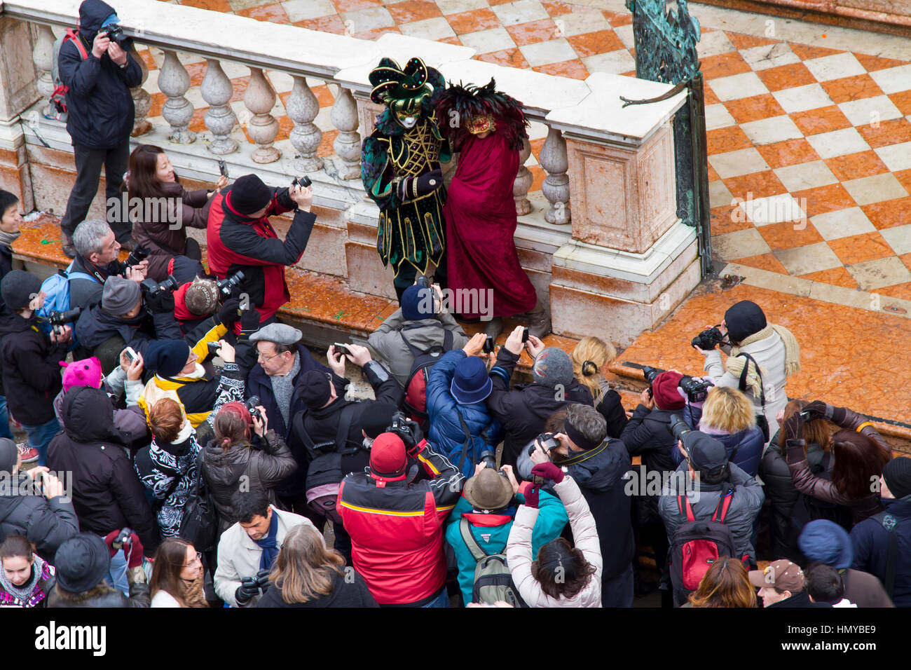 People in fancy dress and photographers in carnival. Stock Photo