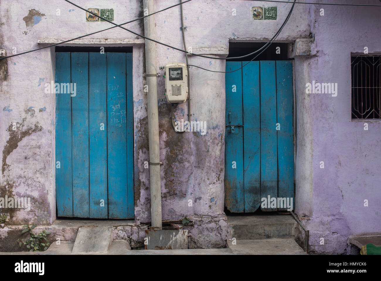 Two blue doors in a lilac painted building, Agra Stock Photo