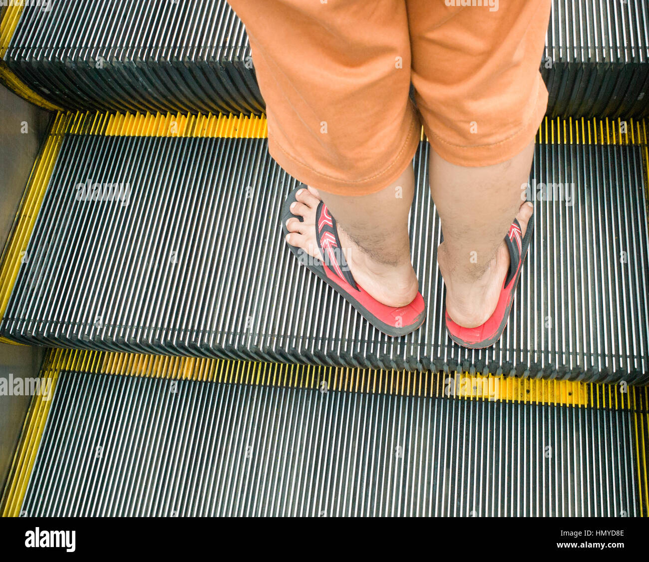 Lower legs and feet of man in flip flops on up escalator, Putrajaya,  Malaysia Stock Photo - Alamy