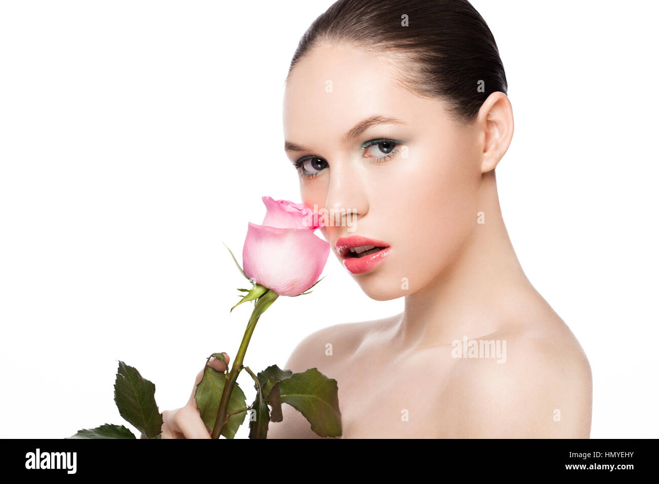 Beauty fashion model girl holding pink rose with natural makeup on white background Stock Photo