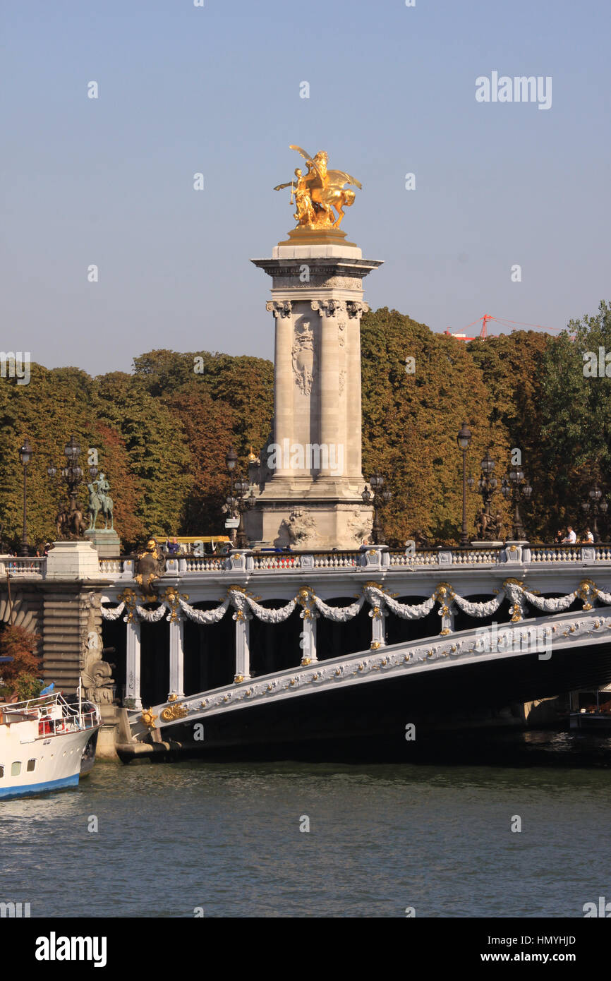 One of the four gilt-bronze statues of Fames watch over the Pont Alexandre III, over River Seine, Paris, France Stock Photo