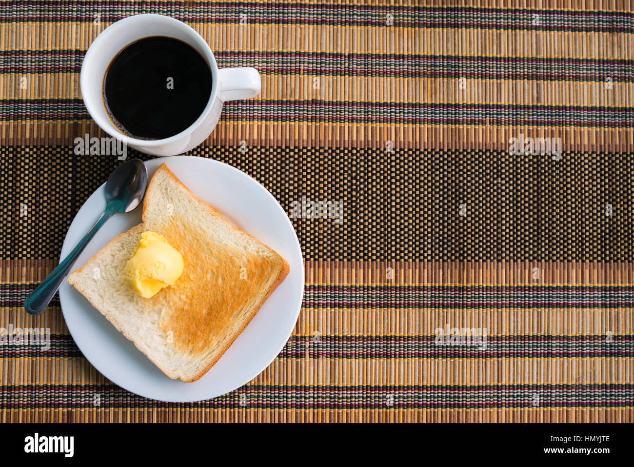 Served table for breakfast with toast, coffee and butter on tablemat with copy-space on right frame Stock Photo
