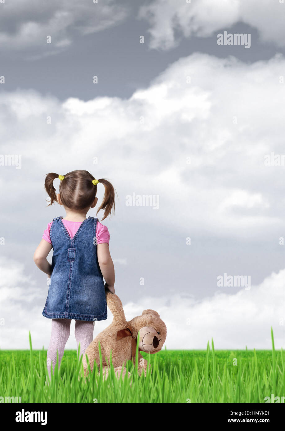 Child girl looking into the distance, back view Stock Photo