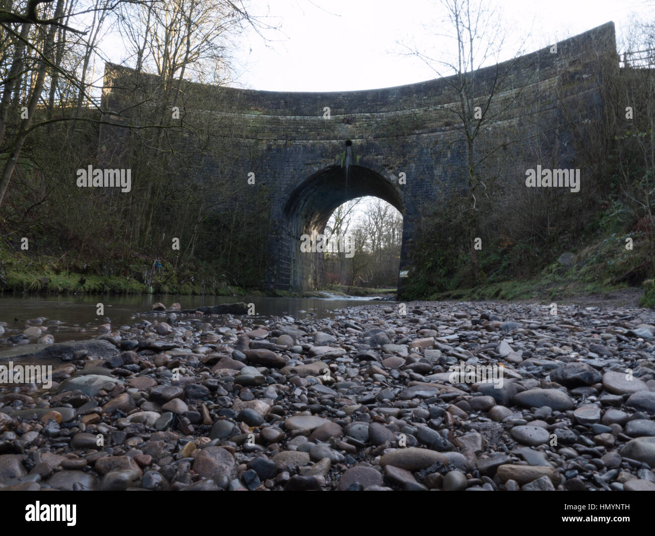 The River Medlock running under the arch of a bridge at Daisy Nook Country Park in Oldham, Greater Manchester Stock Photo