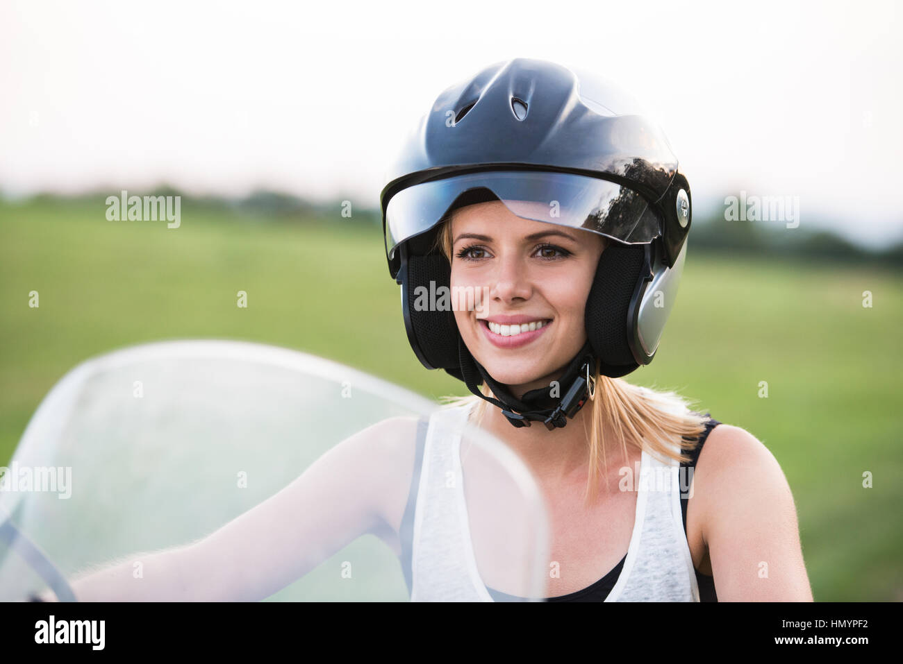 Pretty blond woman enjoying a motorbike ride in countryside Stock Photo ...