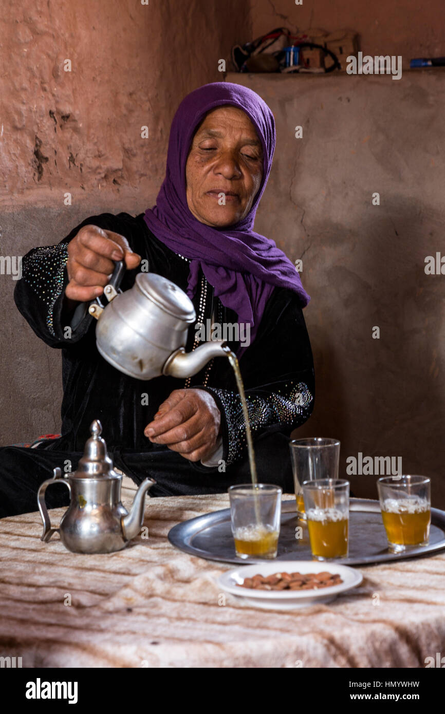 Morocco.  Amazigh Berber Woman Pouring Tea, Ait Benhaddou Ksar, a World Heritage Site. Stock Photo
