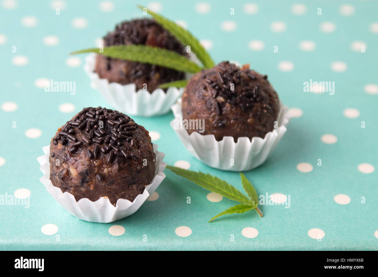 Chocolate truffles in paper holder cups with marijuana leaves Stock