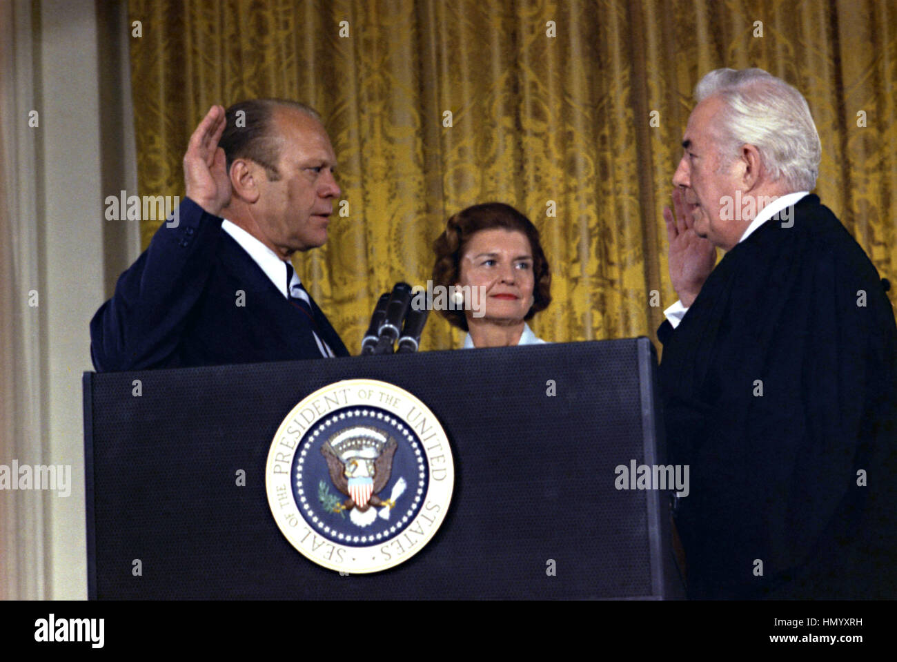 U.S Vice President Gerald Ford takes the oath of office from Supreme Court Chief Justice Warren Burger to become the President of the United States following the resignation of President Richard Nixon in the East Room of the White House August 9, 1974 in Washington, DC. Stock Photo