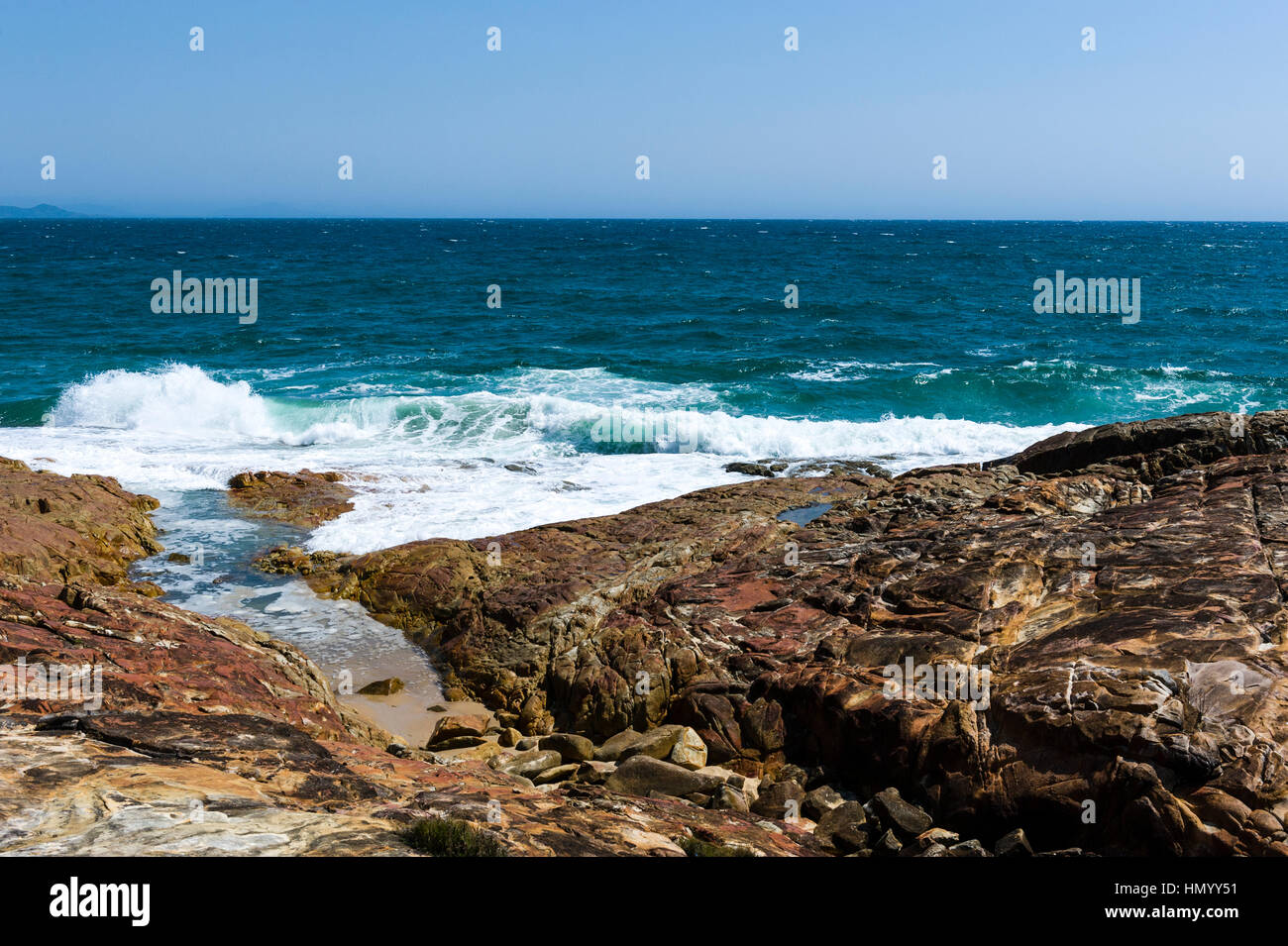 Waves breaking on a rocky headland. Stock Photo