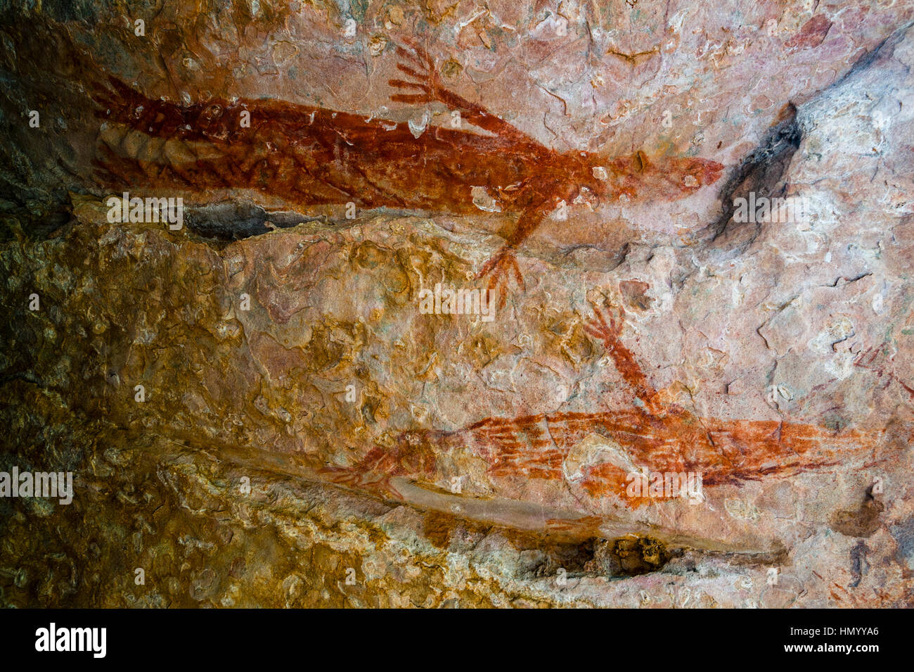 An ancient Wandjina painting featuring animals on the wall of a cave. Stock Photo