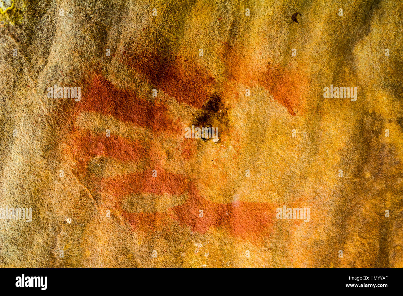 An ancient Wandjina hand stencil on the wall of a cave. Stock Photo