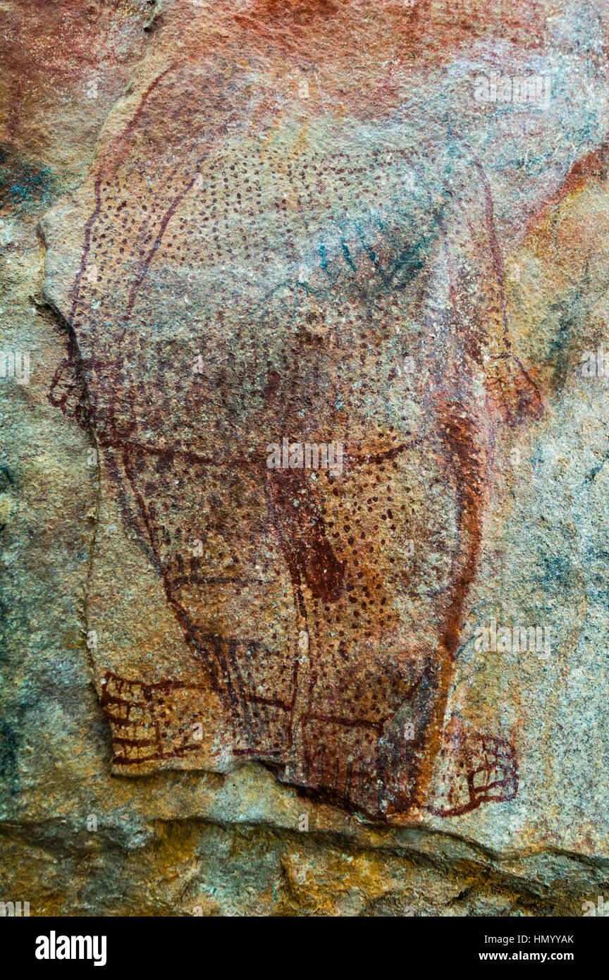 An ancient Wandjina painting featuring a man on the wall of a cave. Stock Photo