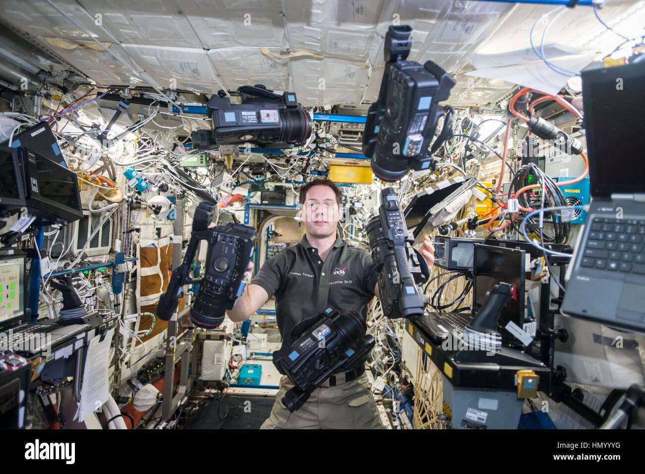 NASA Expedition 50 prime crew member French astronaut Thomas Pesquet of the European Space Agency juggles a set of video cameras in microgravity aboard the International Space Station December 19, 2016 in Earth orbit. Stock Photo