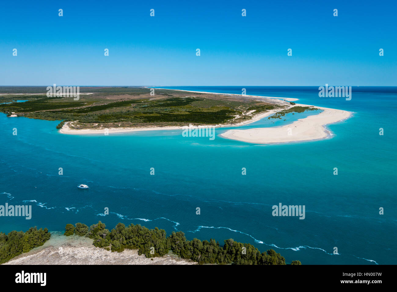 A tidal river inlet and white sandy beach in a pristine turquoise sea. Stock Photo