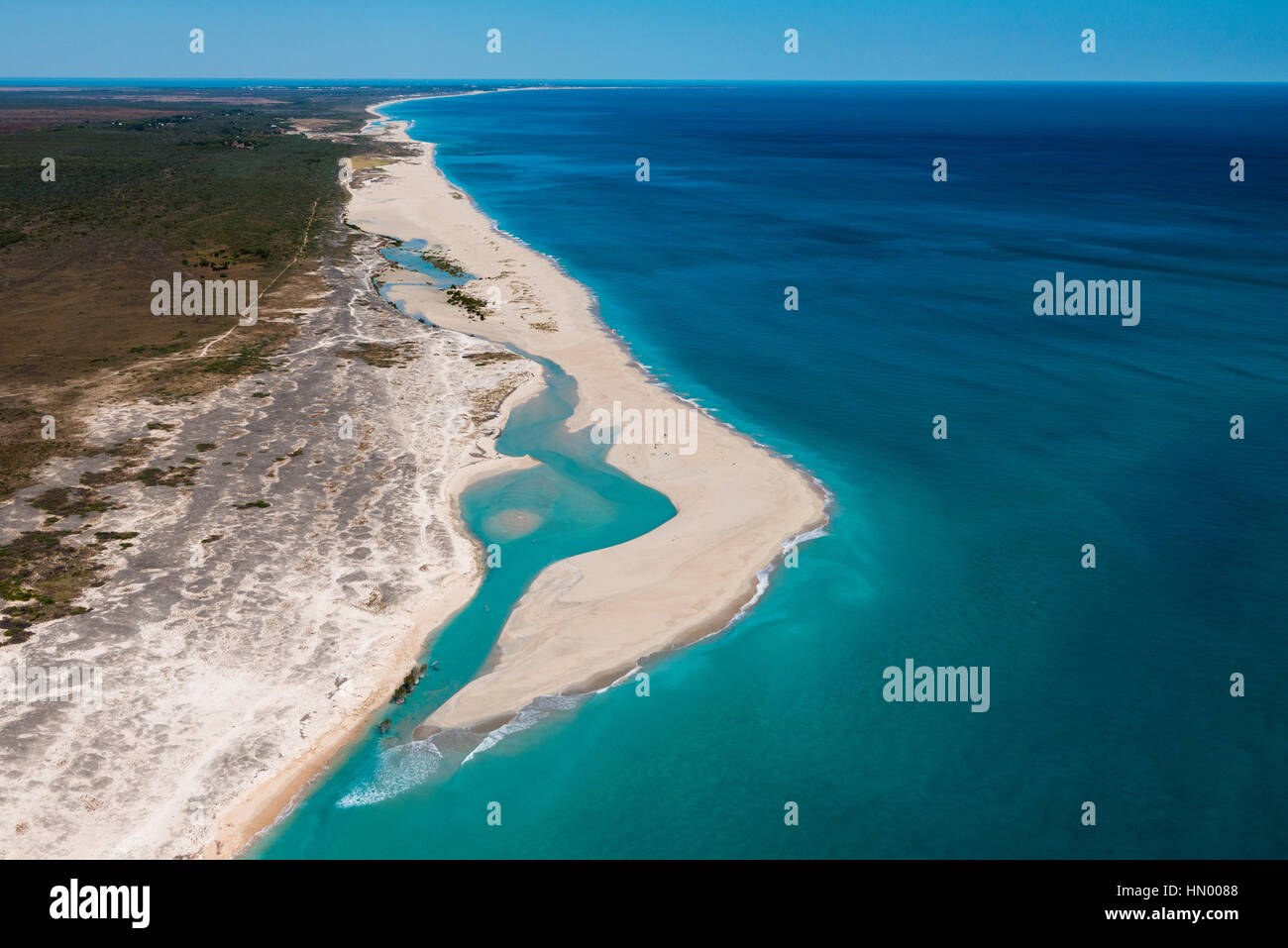 An uninhabited endless white sandy beach along a turquoise sea. Stock Photo