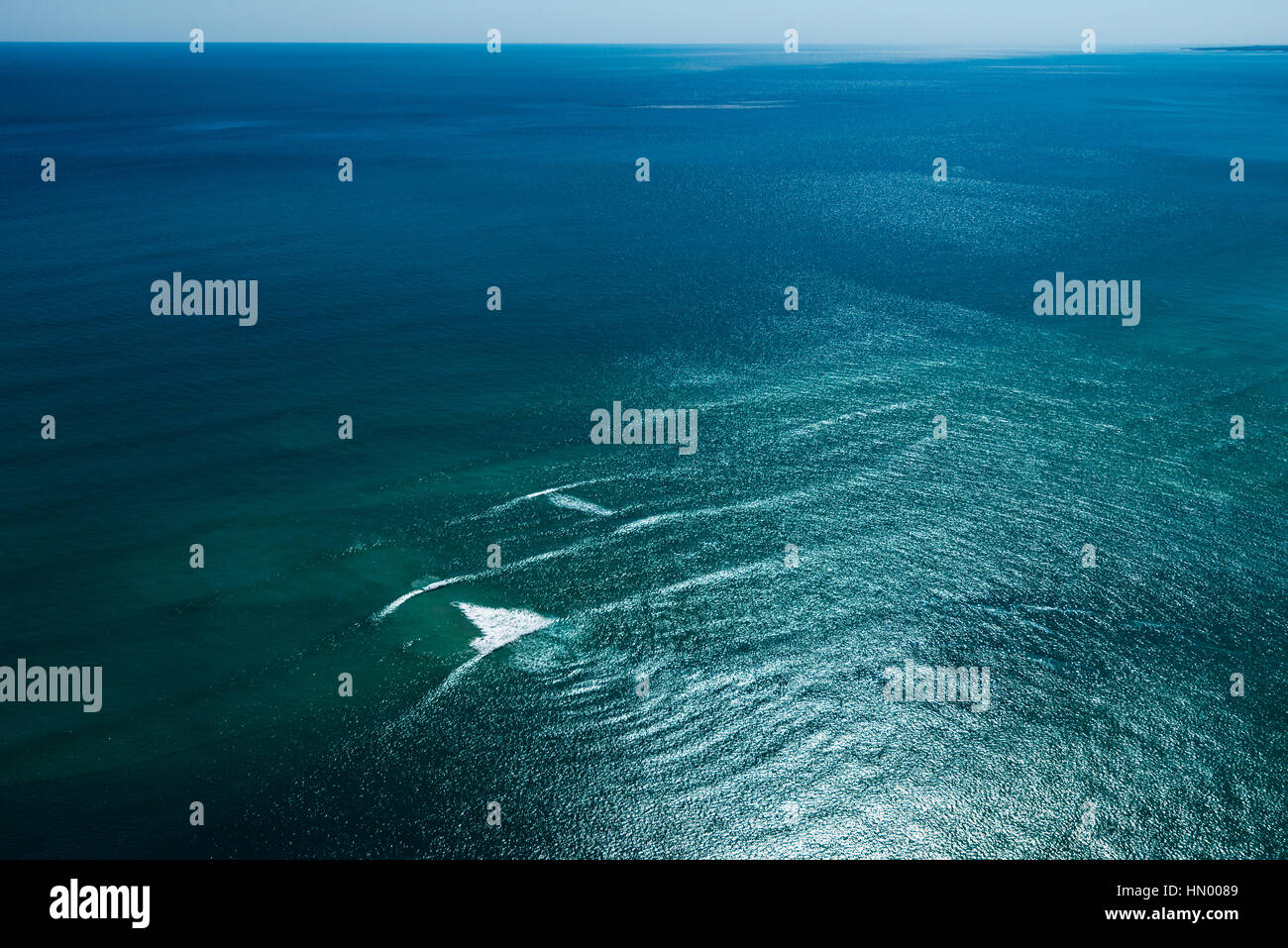 A wave breaks on a sand bar in the ocean. Stock Photo
