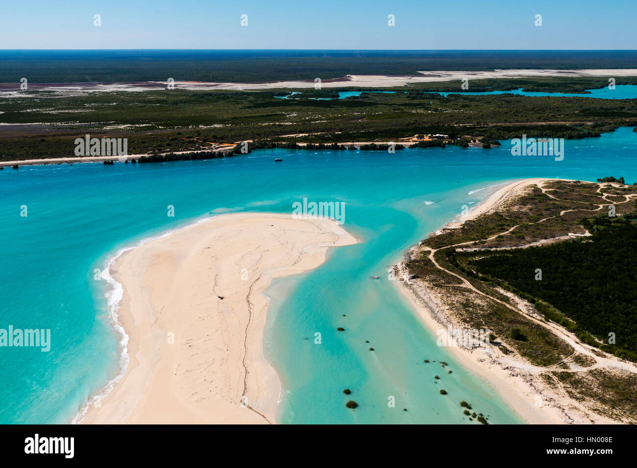 A tidal river inlet and white sandy beach in a pristine turquoise sea. Stock Photo