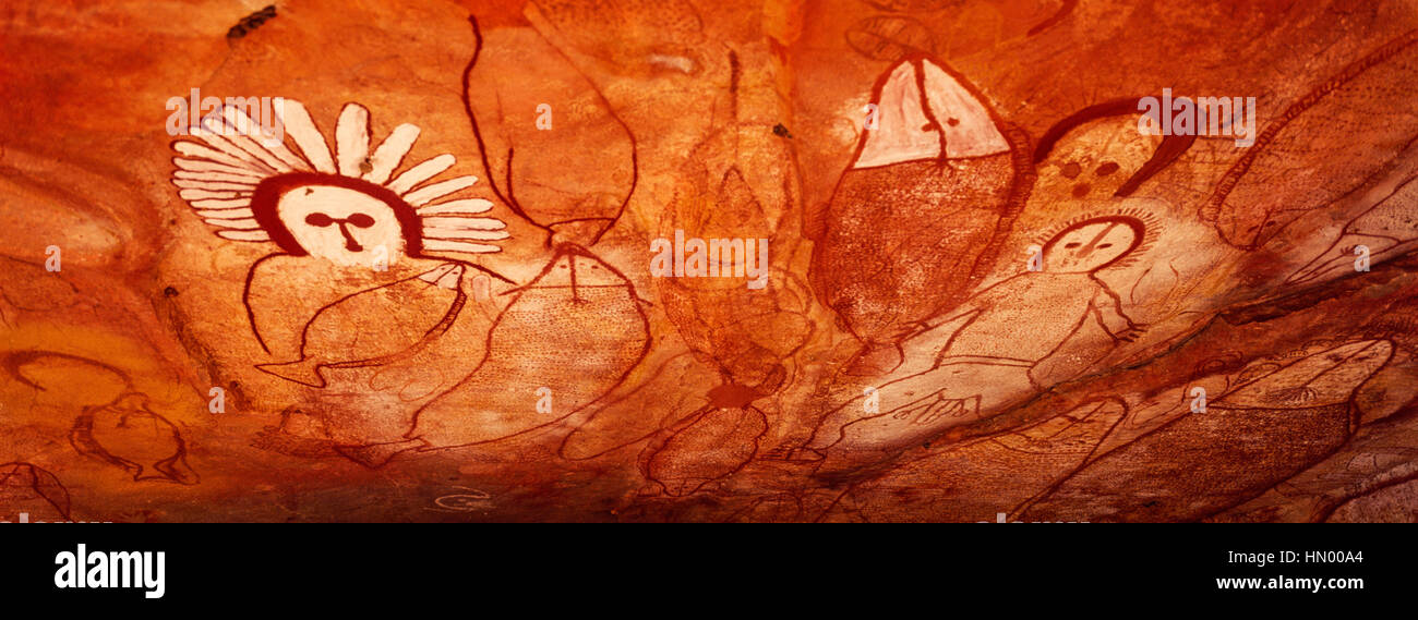 The rich ochre colours of an Aboriginal rock painting gallery featuring The Great Fish Chase. Stock Photo