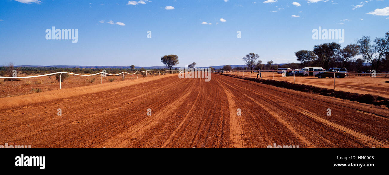 The red ochre sand of an outback horse racing track home straight. Stock Photo