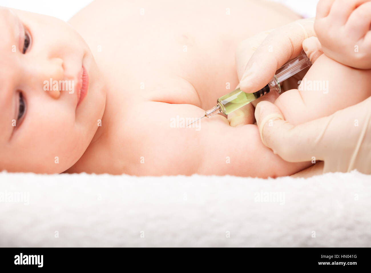 Close-up shot of pediatrician giving a three month baby girl ...