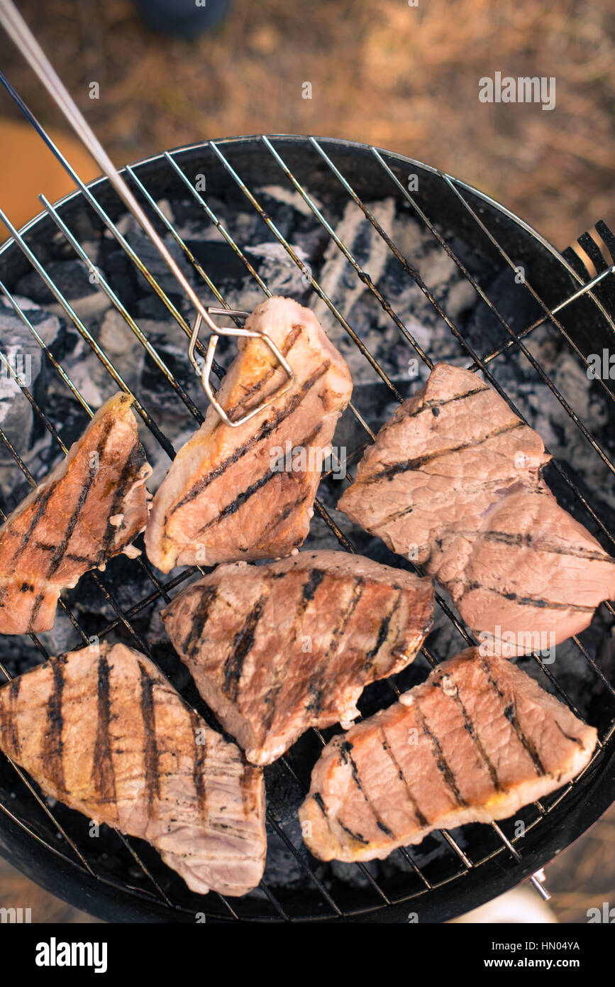 Grilling meat on charcoal grill Stock Photo - Alamy