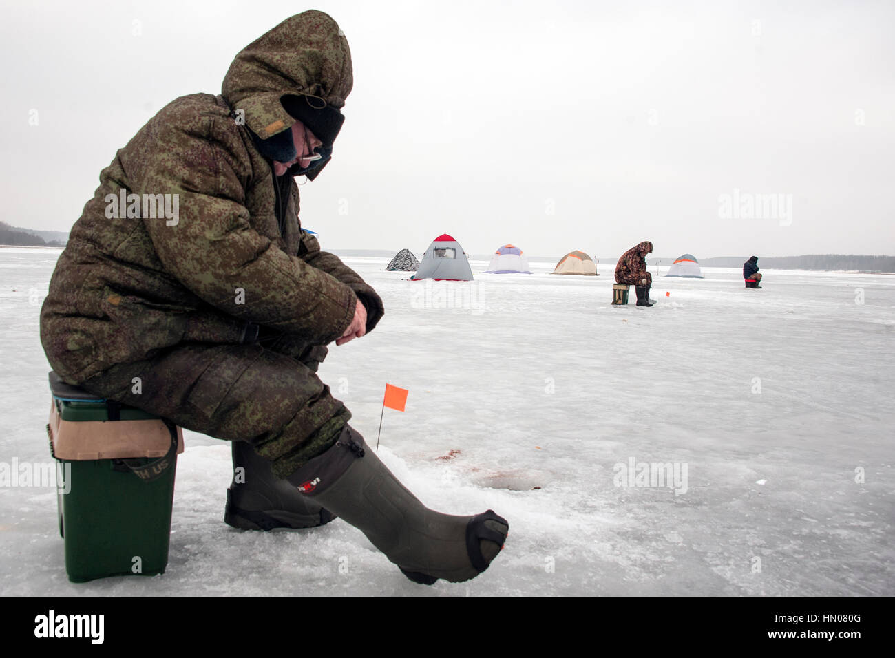 A Russian man on cold winter day as he sits on ice fishing at a river in  Moscow suburbs. Ice fishing is a popular hobby in Russia Stock Photo - Alamy