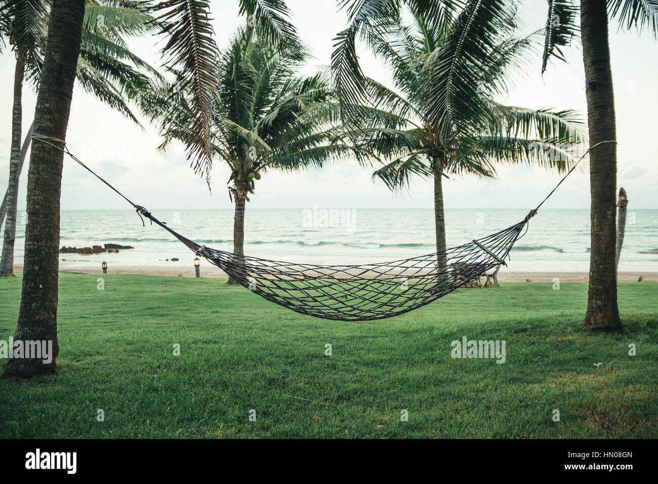 Beach cradle under coconut tree with sea background Stock Photo