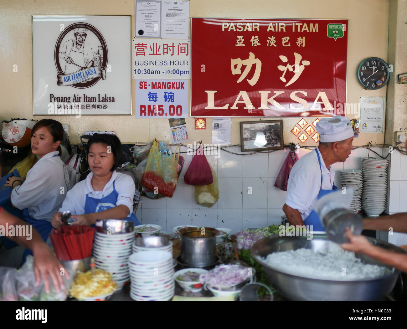 Workers busy at the famous asam laksa noodle stall at Air Itam wet