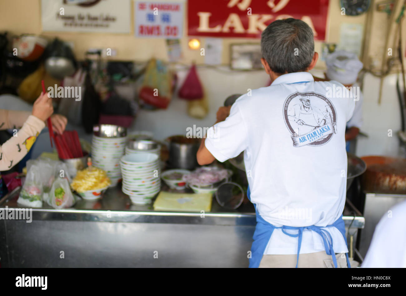 Workers busy at the famous asam laksa noodle stall at Air Itam wet
