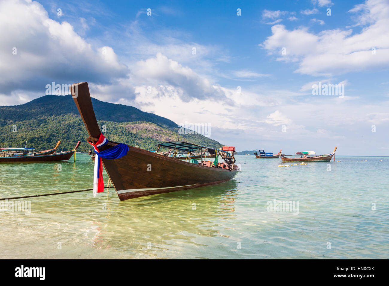 A low angle view of a traditional long tail on a beach in Koh Lipe island in the Andaman sea in south Thailand in Southeast Asia. Stock Photo