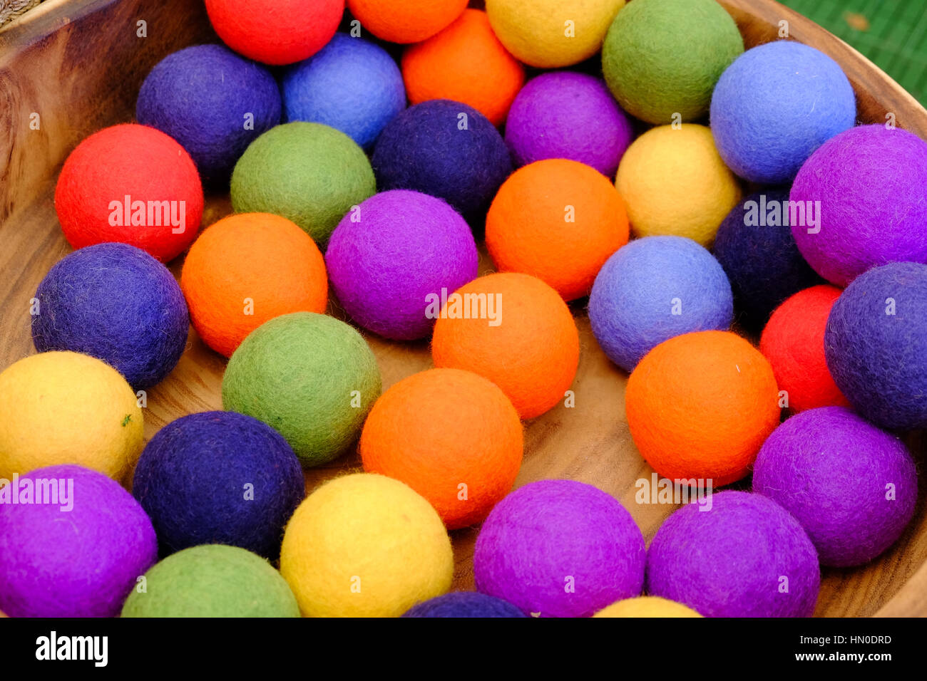 Brightly coloured felt balls for sale on a tray Stock Photo