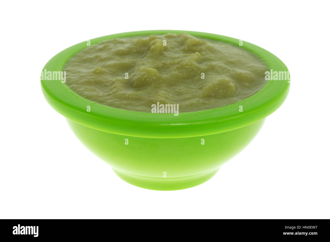 A serving of green peas baby food in a small bowl isolated on a white