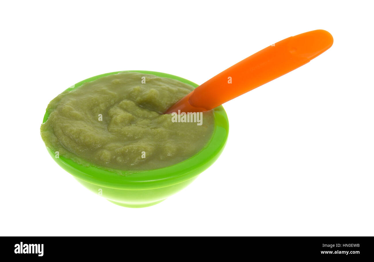 A serving of green peas baby food in a small bowl with an orange spoon