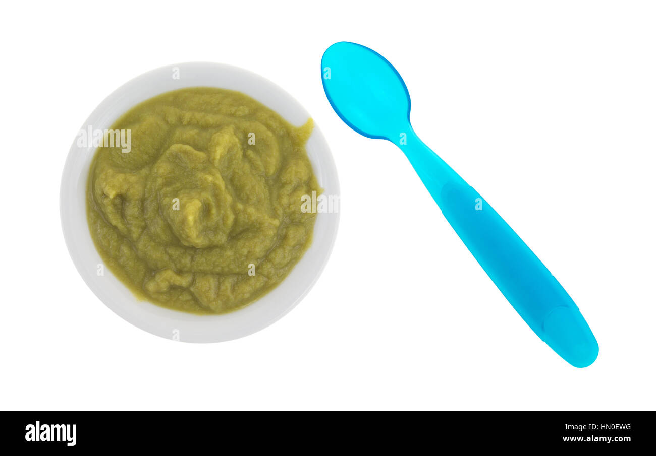 Top view of a serving of green peas baby food in a small bowl with a