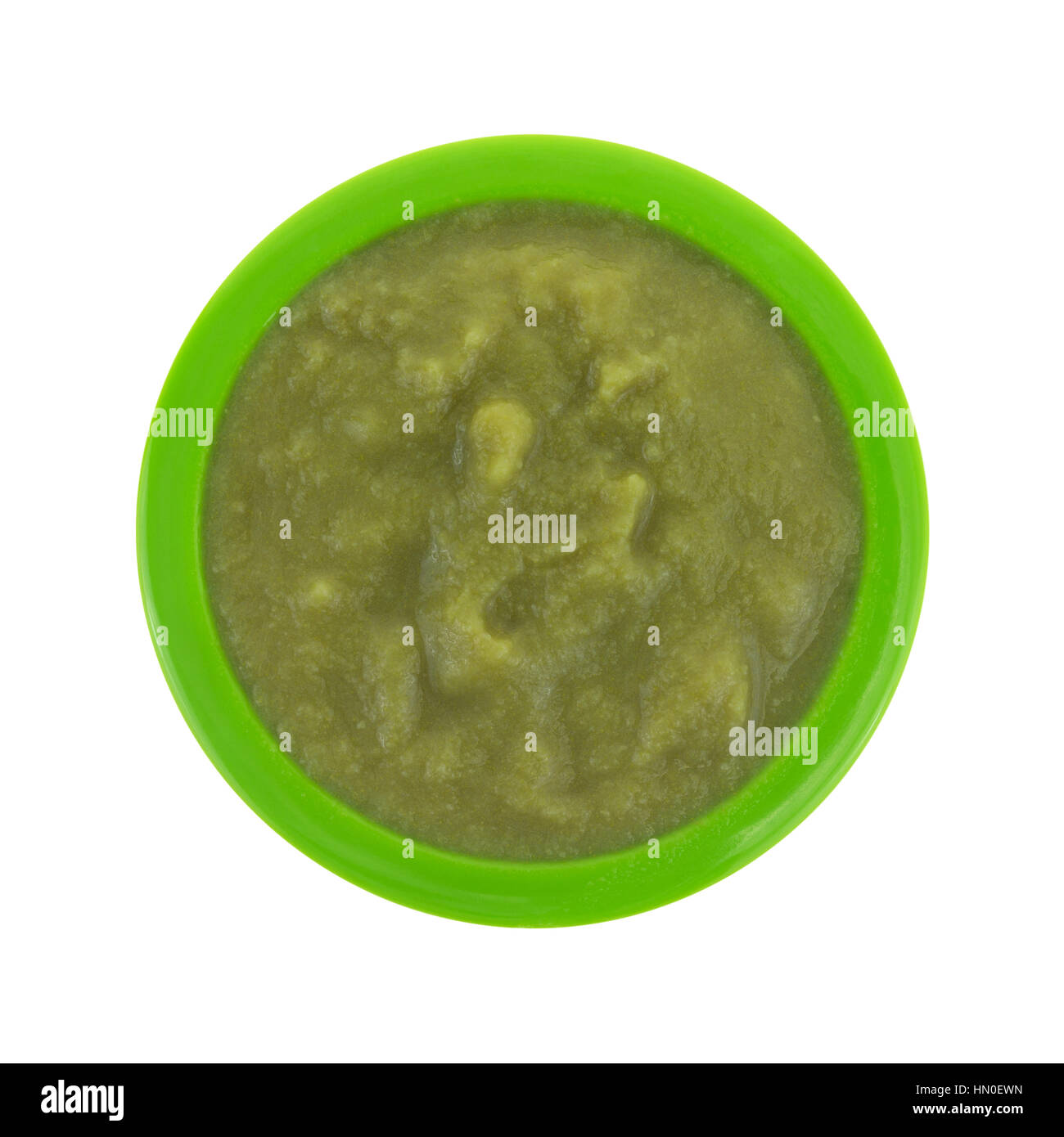 Top view of mushed green peas baby food in a small bowl isolated on a