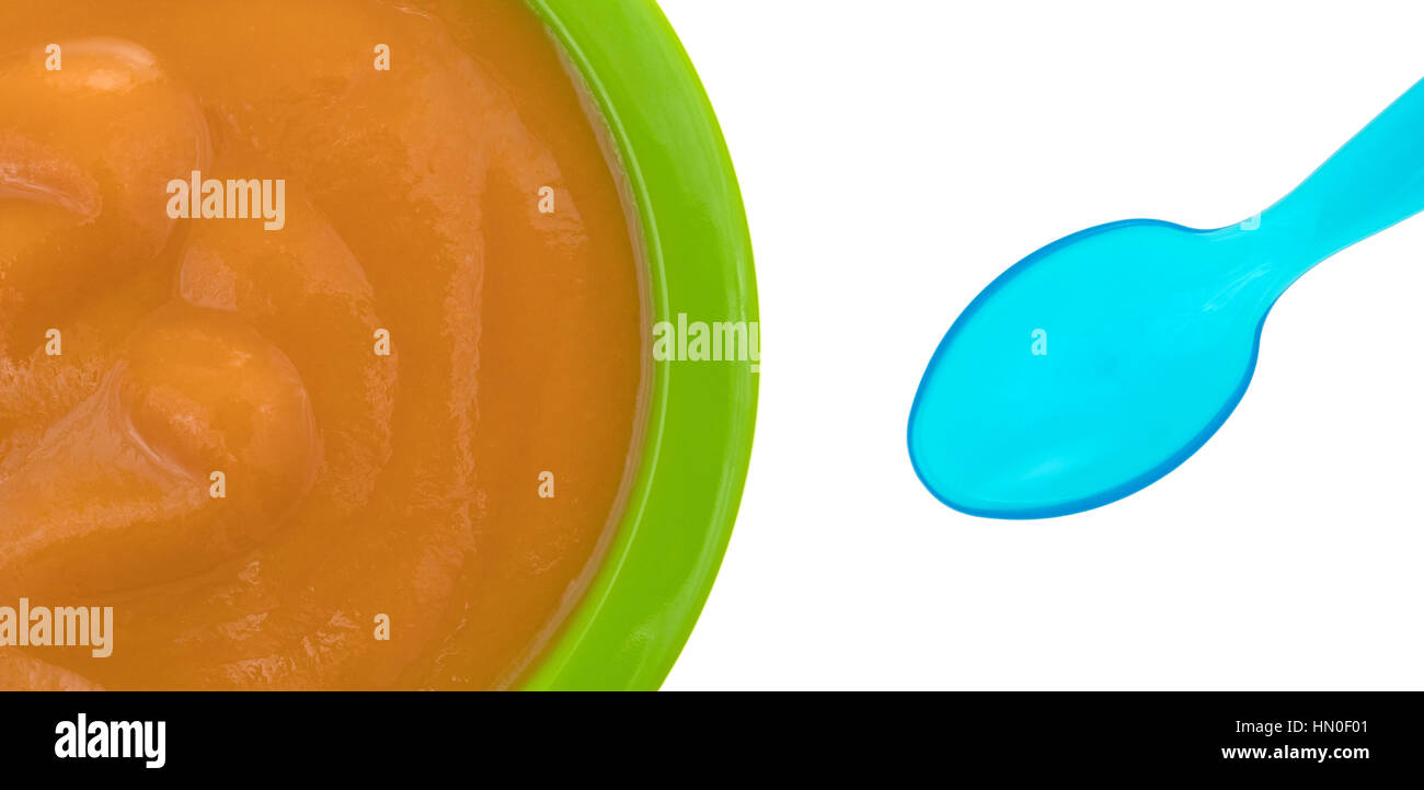 Top view of a serving of banana carrot and mango baby food in a green