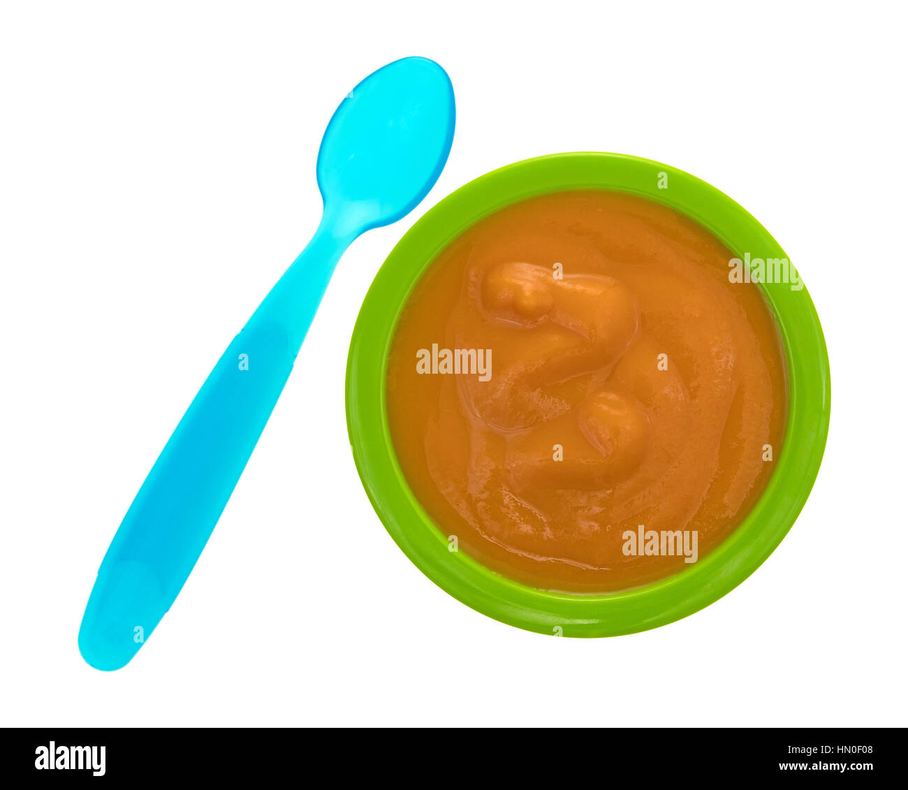 Top view of a serving of banana carrot and mango baby food in a green