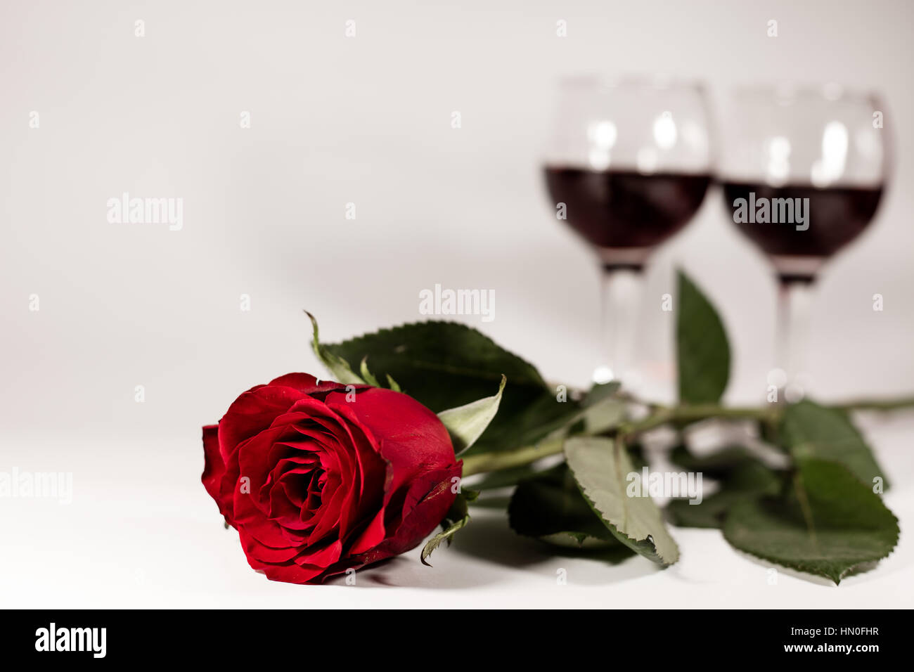 Red rose and red wine on white background Stock Photo