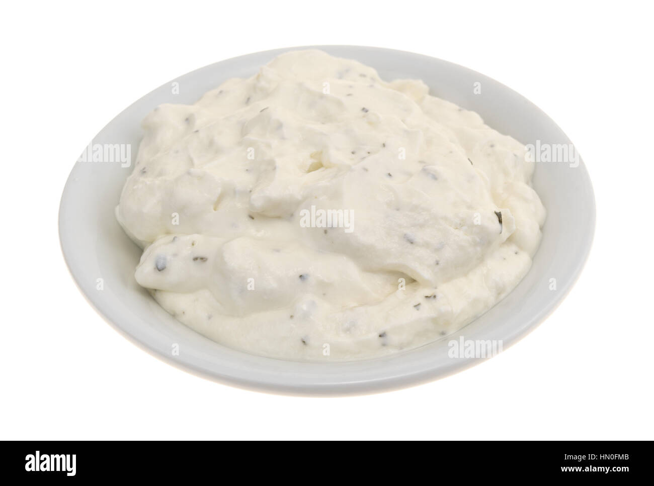 Side view of  a small bowl filled with fresh French onion dip isolated on a white background. Stock Photo