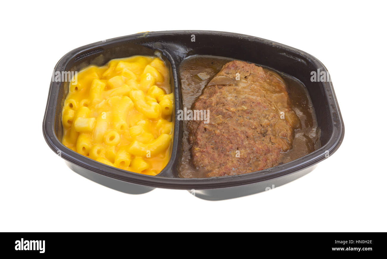 TV dinner meal of salisbury steak with gravy macaroni and cheese in a black tray isolated on a white background. Stock Photo