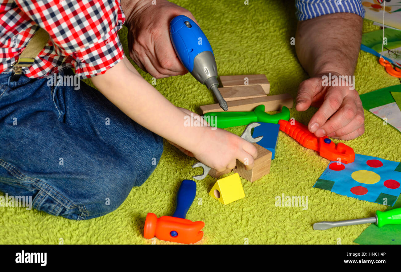 the father teaches the child to use the tool Stock Photo