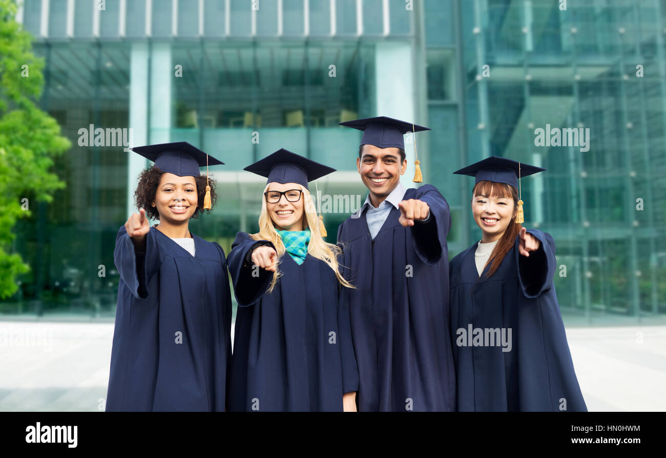 happy students or bachelors pointing finger at you Stock Photo - Alamy