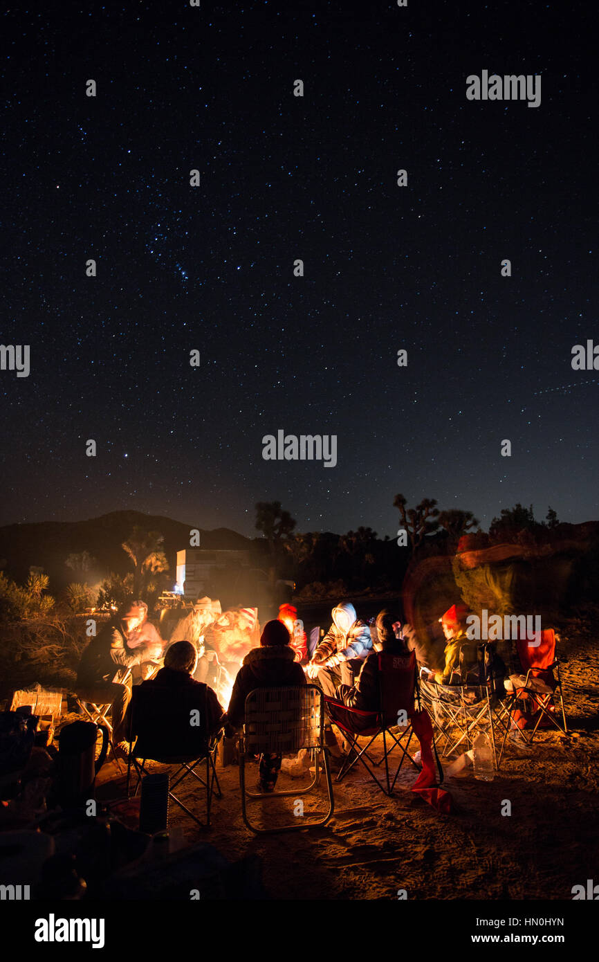 Campers tell stories around a campfire in Joshua Tree National Park. Stock Photo