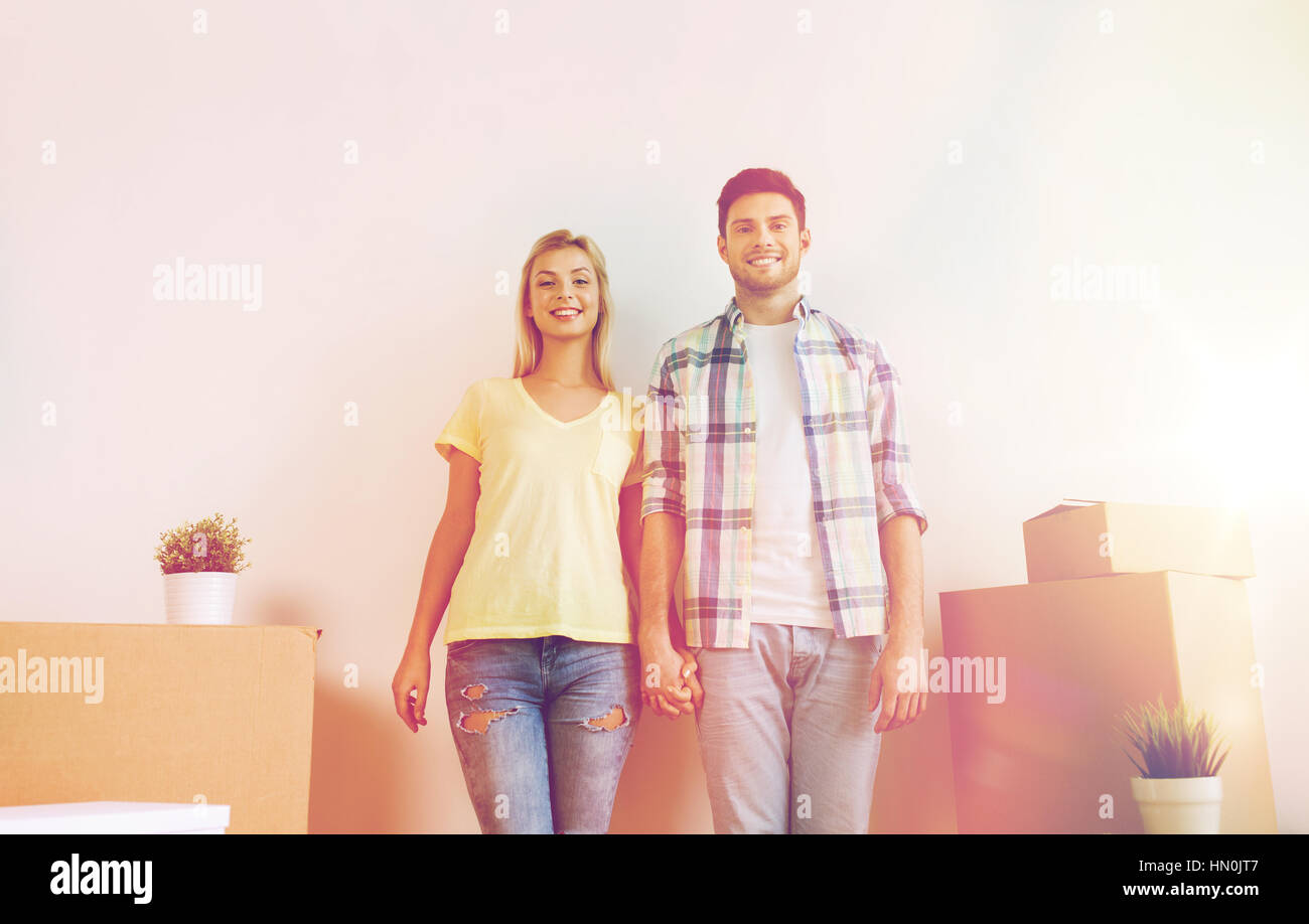 smiling couple with big boxes moving to new home Stock Photo - Alamy