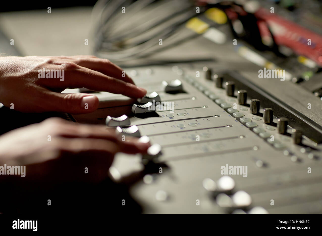 hands on mixing console in music recording studio Stock Photo