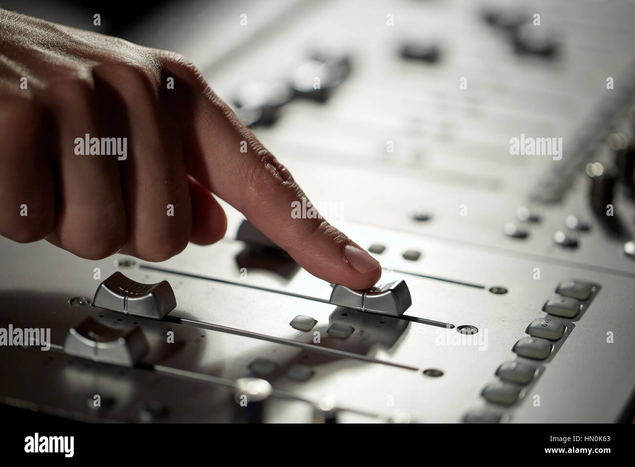 hand with mixing console in music recording studio Stock Photo